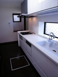 白を基調とした清潔感のあるキッチンと波模様のキッチンタイル
