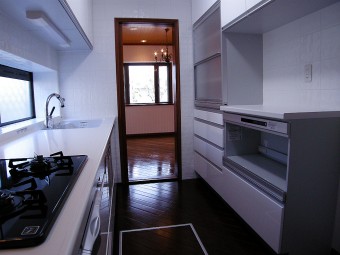 白を基調とした清潔感のあるキッチンと波模様のキッチンタイル